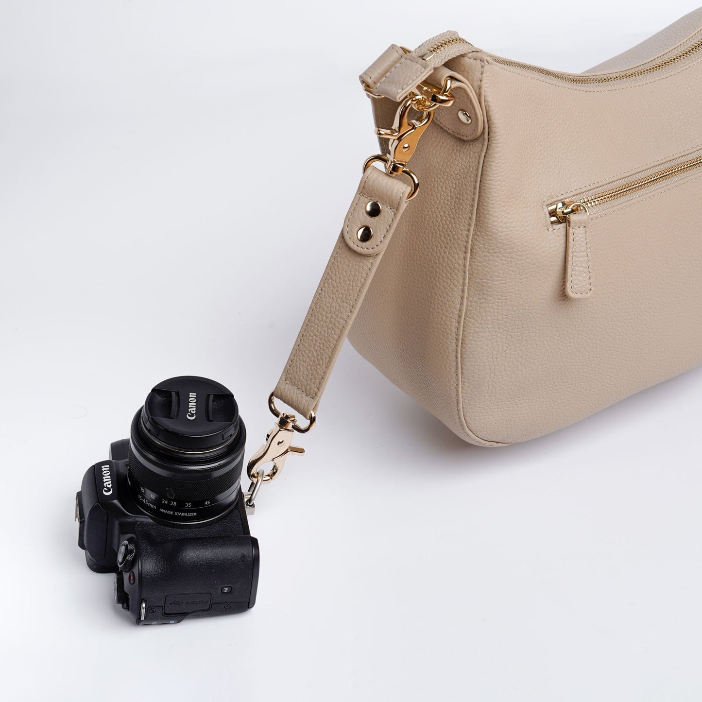 Beige VOYGR Essential Camera Bag Side View with Canon Camera Attached to Clip on Strap
