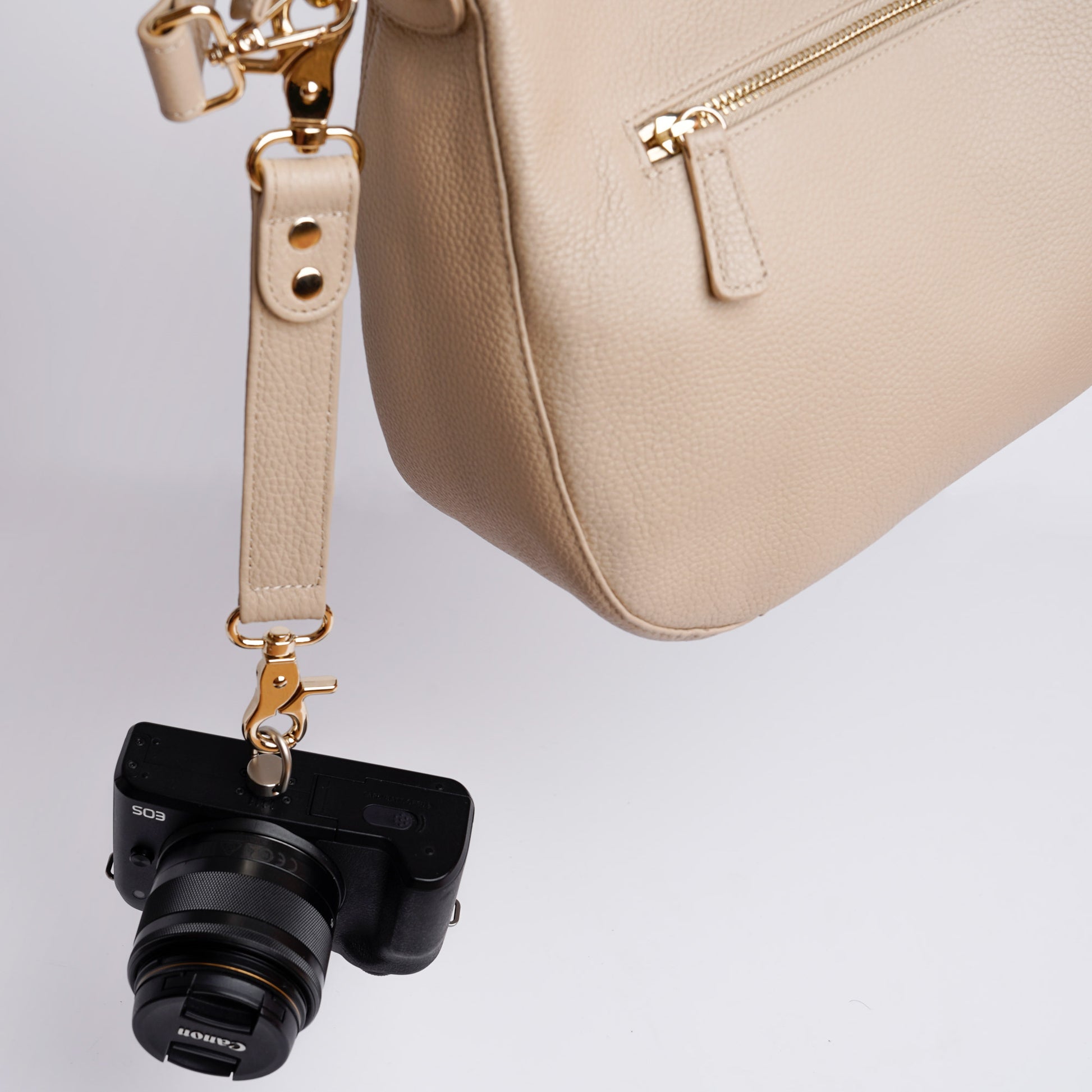 Beige VOYGR Essential Camera Bag with Camera Hanging from Clip on Strap