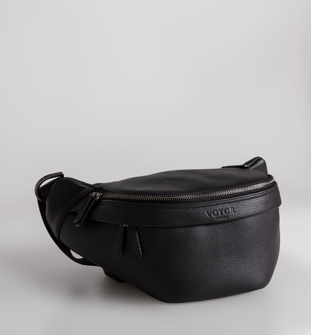A black pebbled leather camera bag with a top zipper and a debossed Voygr London logo on the front, shown on a light gray background.