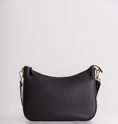 A black pebbled leather crescent-shaped shoulder bag with gold-tone hardware and a small debossed 'VOYAGE' logo on the front, set against a plain light gray background.