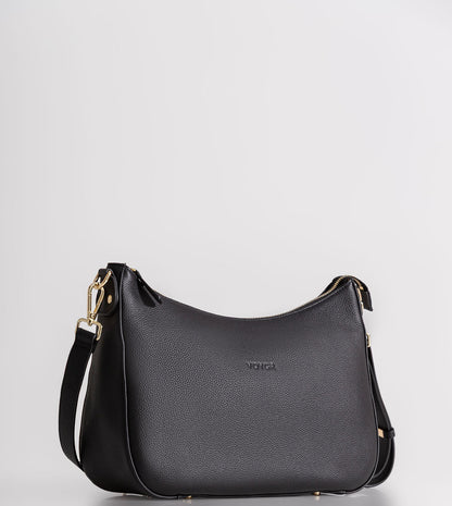 A black pebbled leather crescent-shaped shoulder bag with gold-tone hardware and a small debossed 'MCKINNEY' logo on the front, set against a plain light gray background.